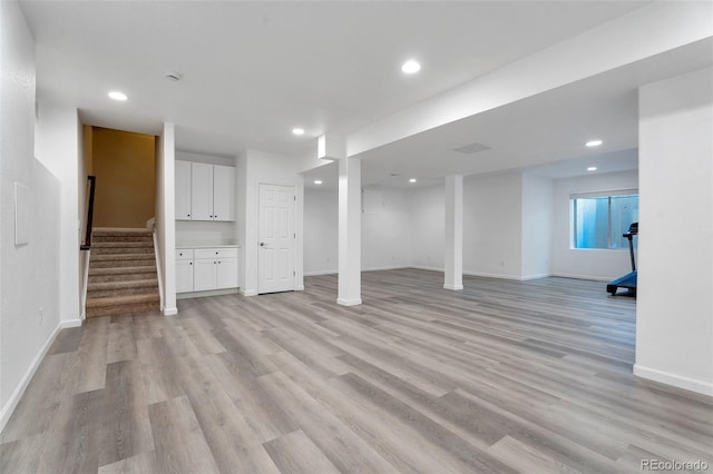 basement with light hardwood / wood-style flooring