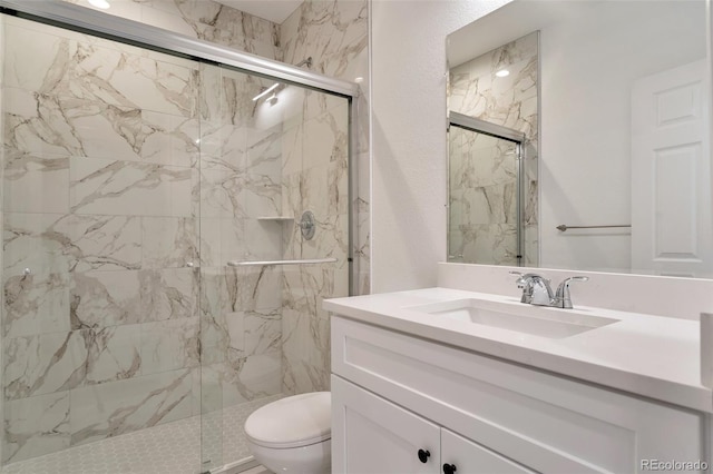 bathroom with vanity, toilet, and a shower with door