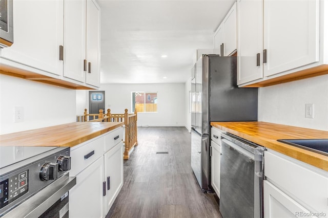 kitchen with baseboards, dark wood finished floors, stainless steel appliances, white cabinets, and butcher block counters