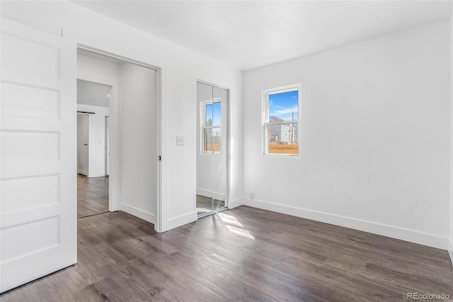 unfurnished bedroom featuring wood finished floors and baseboards