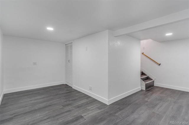 finished below grade area featuring stairway, recessed lighting, dark wood-style floors, and baseboards