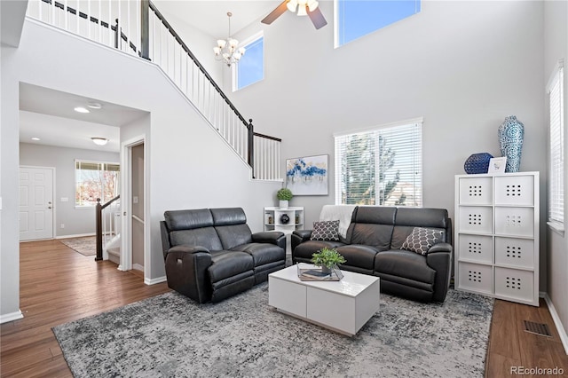 living room with a high ceiling, plenty of natural light, and wood-type flooring