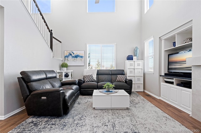 living room with dark hardwood / wood-style flooring and a high ceiling