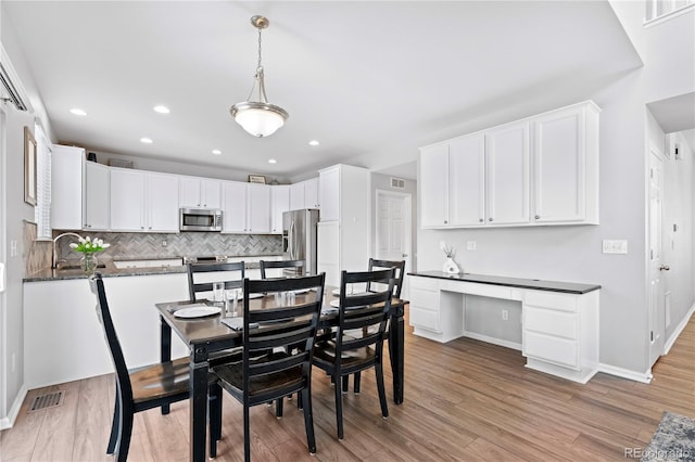 dining space with light hardwood / wood-style floors and sink