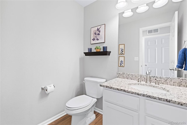 bathroom with hardwood / wood-style flooring, vanity, and toilet