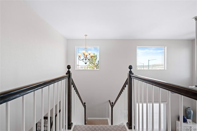 staircase with an inviting chandelier