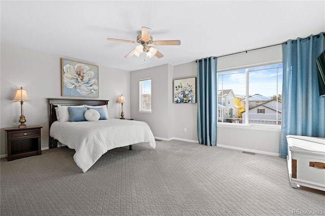 carpeted bedroom featuring multiple windows and ceiling fan