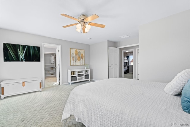 carpeted bedroom with ceiling fan, a spacious closet, and a closet