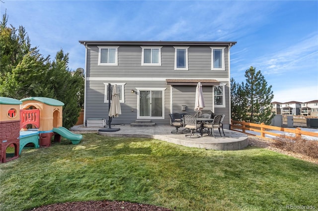 rear view of house with a playground, a patio area, and a lawn