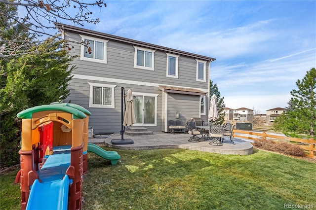 rear view of property with a playground, a yard, and a patio