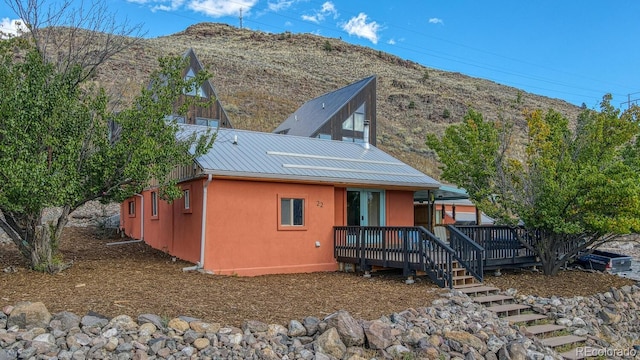 rear view of house with a deck with mountain view