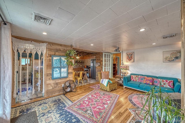 living room with wood walls and wood-type flooring