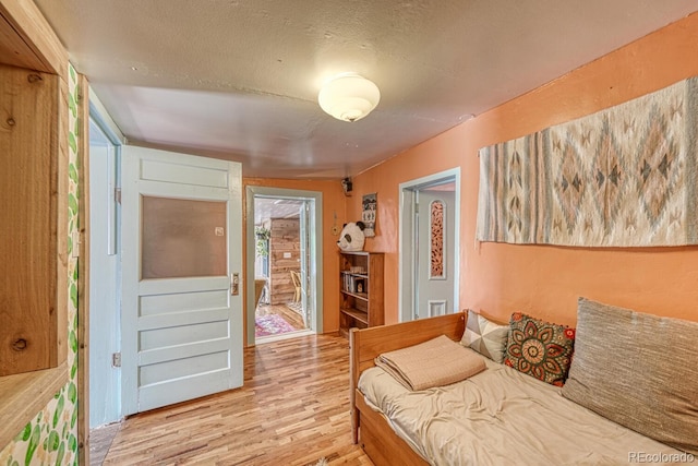 bedroom featuring hardwood / wood-style flooring, a textured ceiling, and connected bathroom