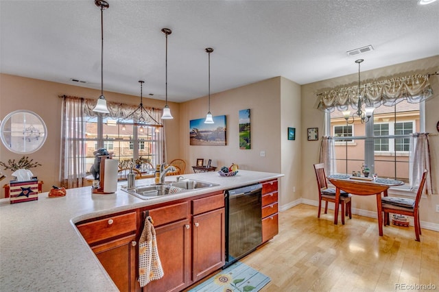 kitchen featuring black dishwasher, visible vents, light countertops, a chandelier, and a sink