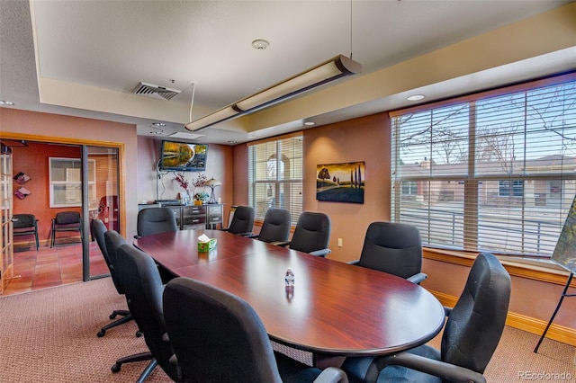 carpeted office featuring a raised ceiling, visible vents, and baseboards