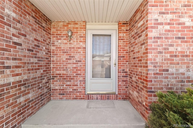 doorway to property featuring brick siding