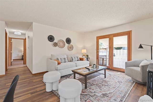 living room featuring a textured ceiling, wood finished floors, and baseboards