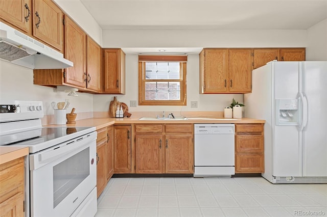 kitchen with under cabinet range hood, white appliances, a sink, light countertops, and brown cabinetry