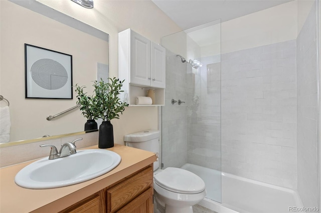 full bathroom featuring vanity, a tile shower, and toilet