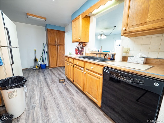 kitchen with light wood-style flooring, a sink, light countertops, black dishwasher, and backsplash