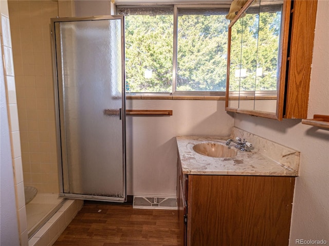 full bath featuring wood finished floors, a stall shower, and vanity