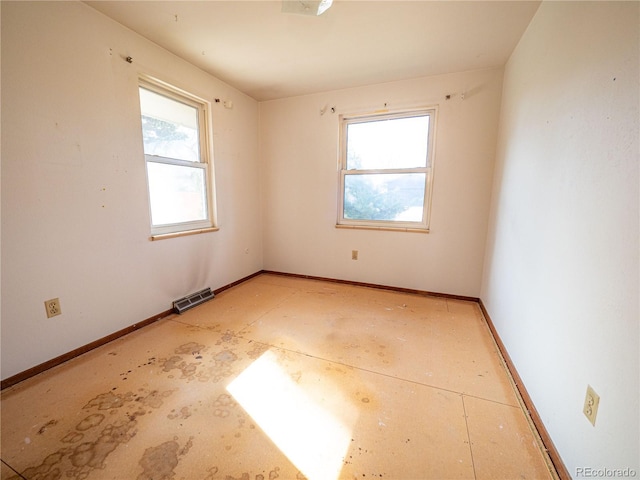 spare room featuring visible vents, plenty of natural light, and baseboards