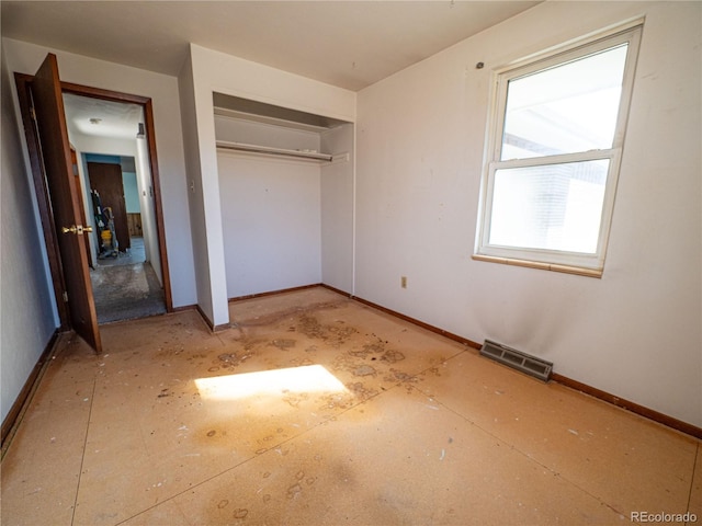 unfurnished bedroom with visible vents, baseboards, and a closet