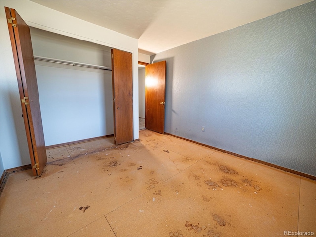 unfurnished bedroom with a closet and baseboards