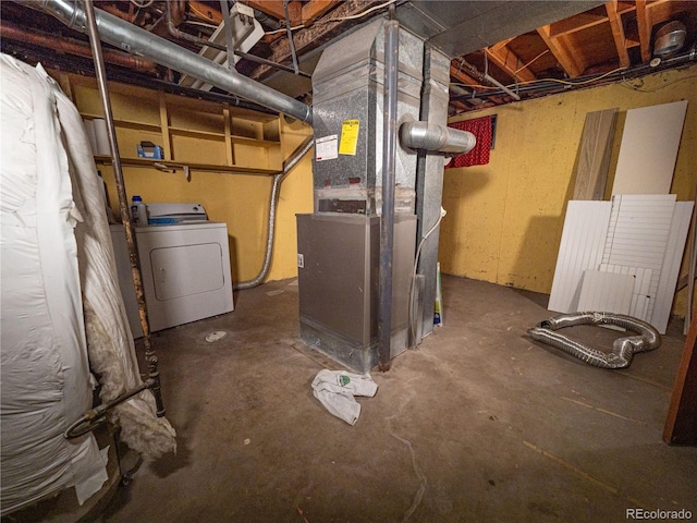 unfinished basement featuring heating unit and washer / dryer