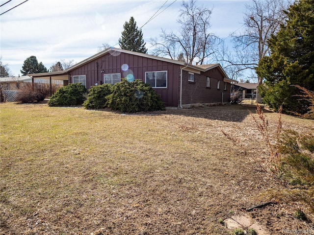 view of home's exterior featuring board and batten siding, a yard, and fence