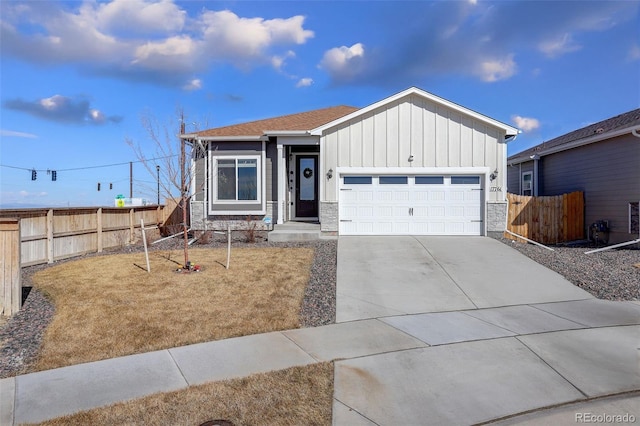 view of front facade with board and batten siding, fence, driveway, and an attached garage