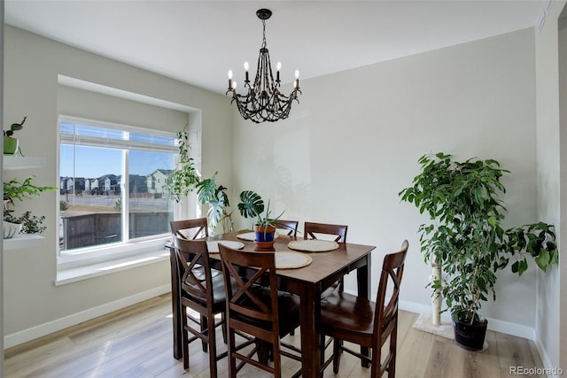 dining space featuring light wood-style floors and baseboards