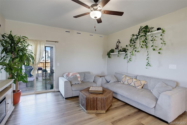 living area featuring light wood-style floors, visible vents, and ceiling fan