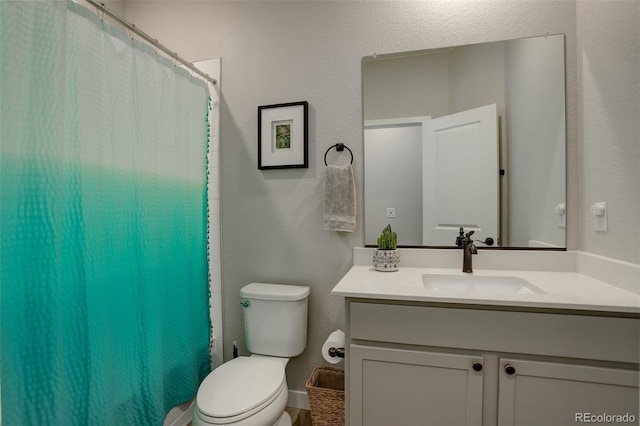 full bath featuring a shower with curtain, a textured wall, vanity, and toilet