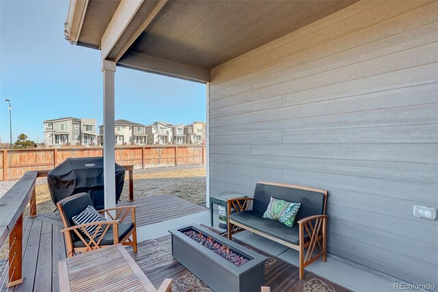 wooden deck with fence private yard, an outdoor fire pit, a residential view, and area for grilling