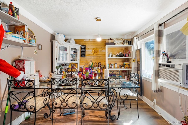 dining area with wood walls, hardwood / wood-style flooring, a textured ceiling, and cooling unit