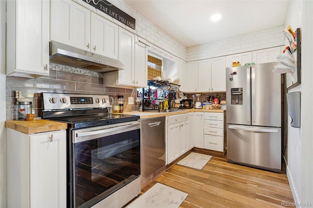 kitchen featuring white cabinets, light wood-type flooring, stainless steel appliances, and wood counters