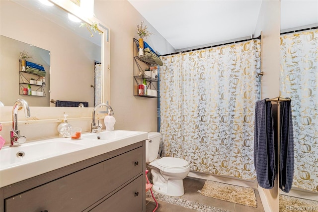 bathroom with toilet, vanity, and tile patterned floors