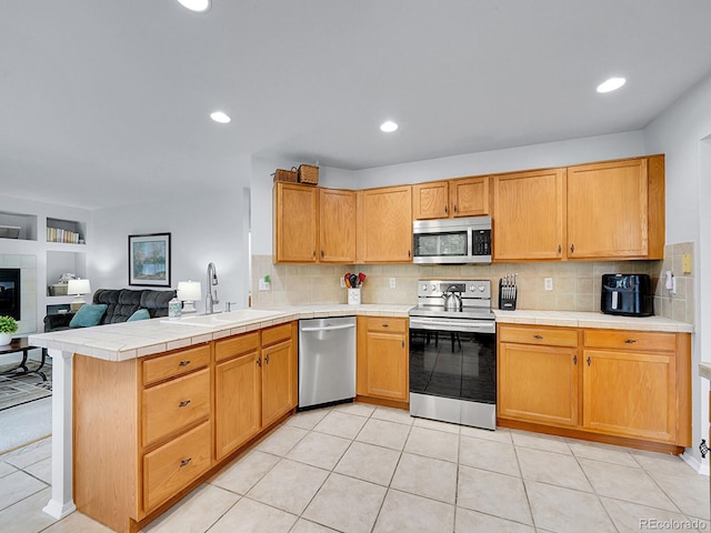 8838 S Dudley St, Littleton, CO 80128 - kitchen with stainless steel appliances, a sink, a peninsula, tasteful backsplash, and recessed lighting