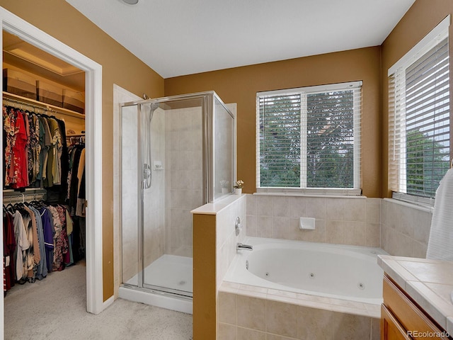 8838 S Dudley St, Littleton, CO 80128 - bathroom featuring a tub with jets, a stall shower, a spacious closet, and vanity