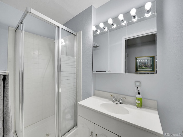 8838 S Dudley St, Littleton, CO 80128 - bathroom featuring vanity, a stall shower, and a textured wall