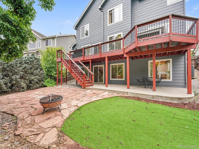8838 S Dudley St, Littleton, CO 80128 - back of property featuring an outdoor fire pit, a patio area, a deck, stairs, and a lawn