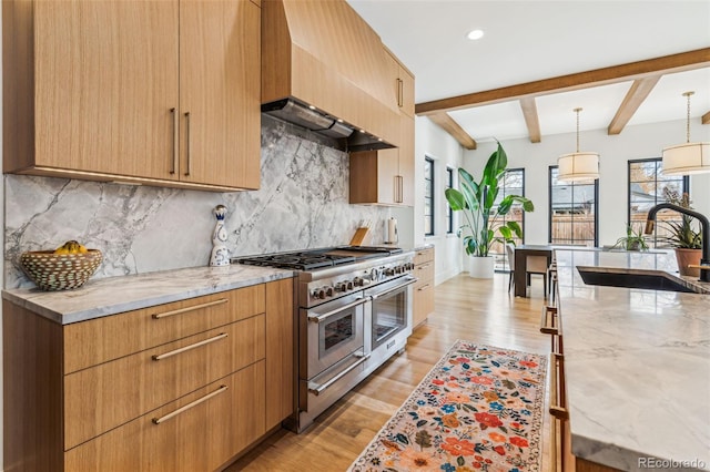 kitchen with range with two ovens, a sink, light stone counters, beamed ceiling, and backsplash