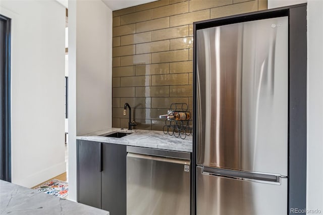 indoor wet bar with stainless steel appliances and decorative backsplash