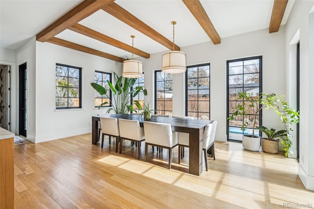 dining space with healthy amount of natural light, beam ceiling, light wood-style flooring, and baseboards