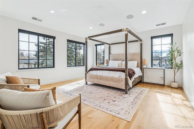 bedroom with baseboards, light wood finished floors, and recessed lighting