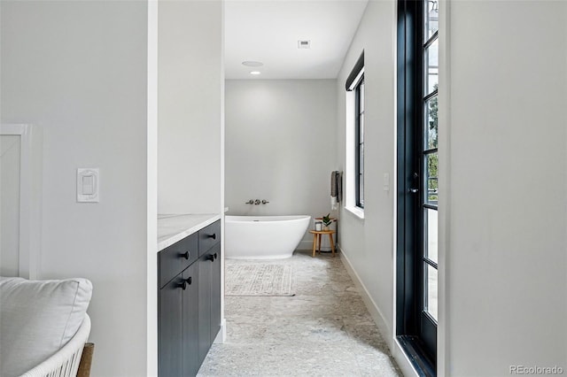 bathroom featuring a freestanding bath and baseboards