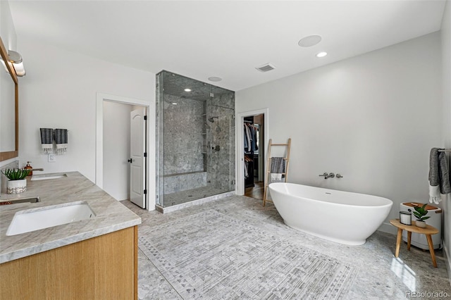 full bath featuring a shower stall, a freestanding bath, and double vanity