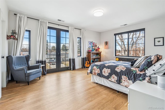 bedroom with french doors, light wood-style floors, and access to exterior