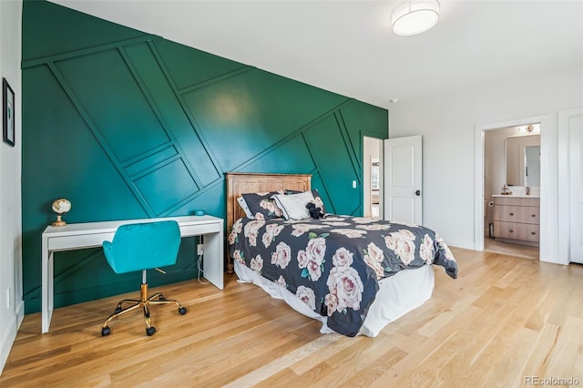 bedroom featuring a decorative wall and wood finished floors